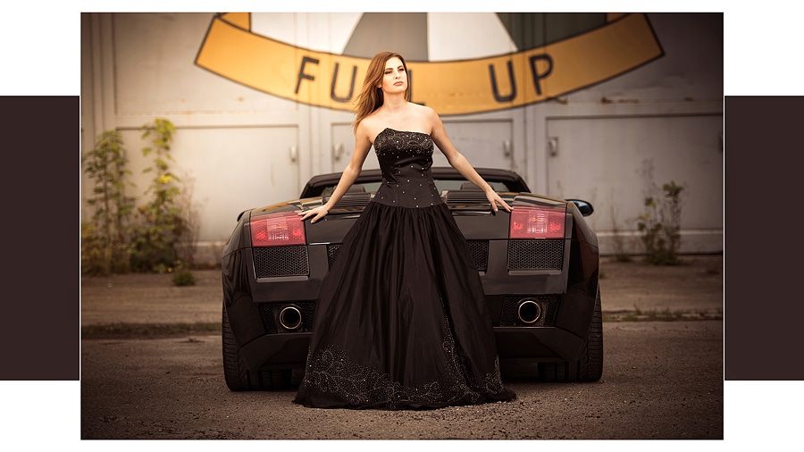 Lady in Black mit Stier - Lady in Black mit Stier - stehende junge Frau im schwarzem Abendkleid vor einem Lamborghini Gallardo und ein großes Hallentor im Hintergrund